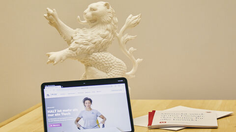 Tablet vor stehendem Hessenlöwe und Dokumentationen