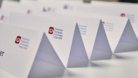 Hintereinander aufgereite Namensschilder der Jury mit Staatspreis Logo